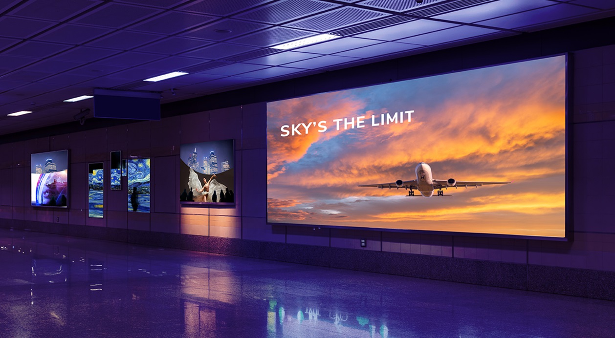 Videowall de gran formato ubicado en un espacio público o metro para publicidad digital exterior, junto con varias pantallas de señalización digital multipantalla.